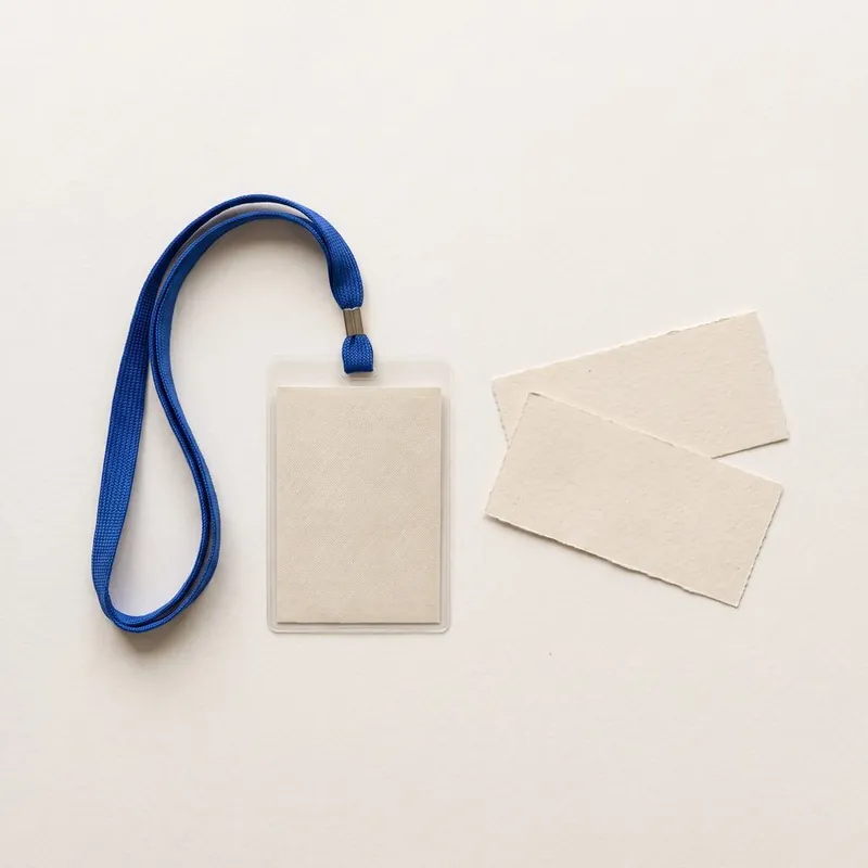 A blank conference badge on a lanyard next to paper tickets
