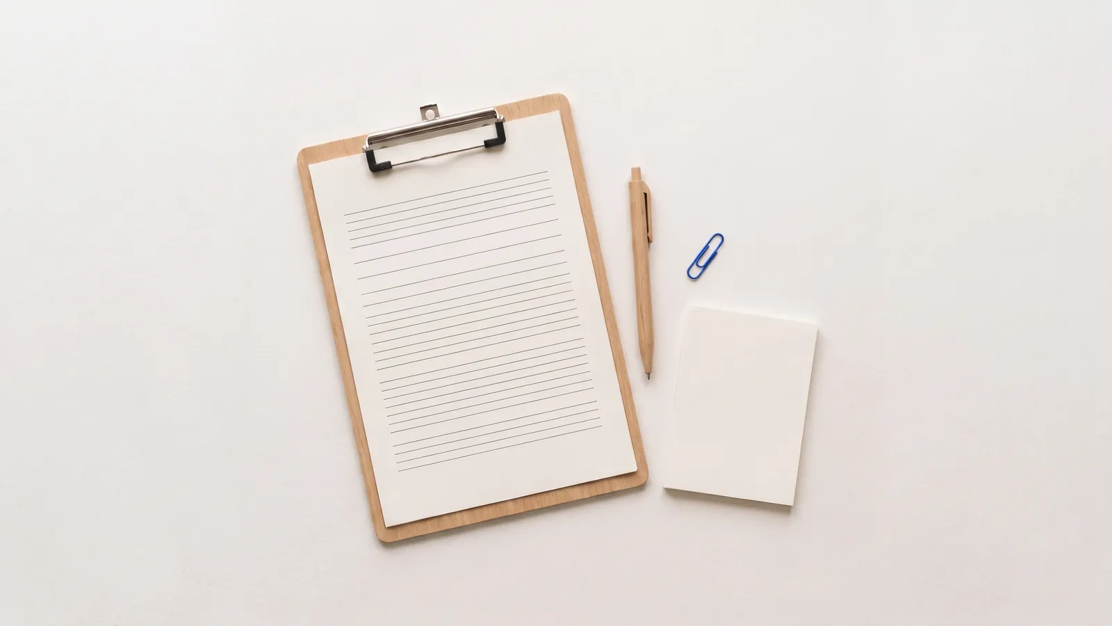 A clipboard holding a blank application form next to a pen